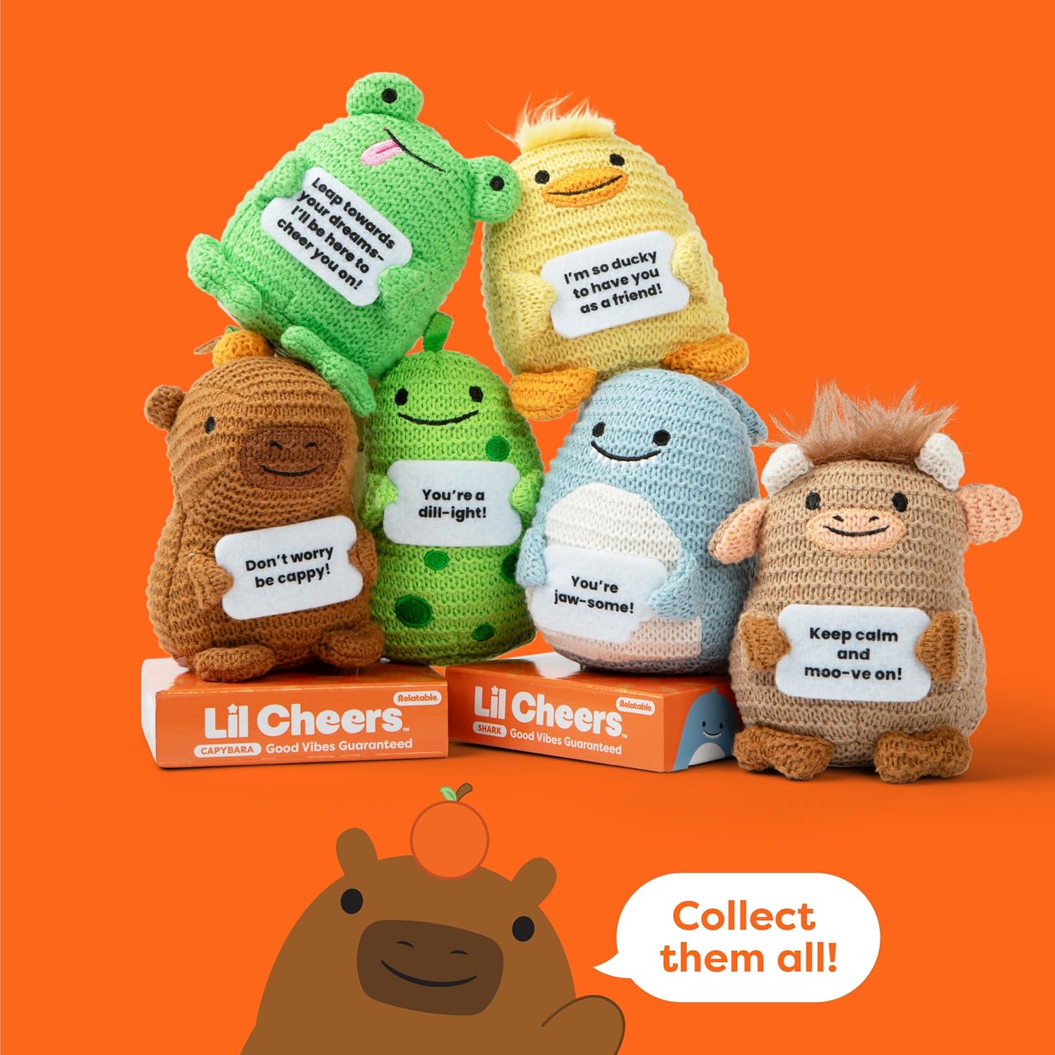 Small crochet-style capybara plush sitting upright, holding a tiny felt sign