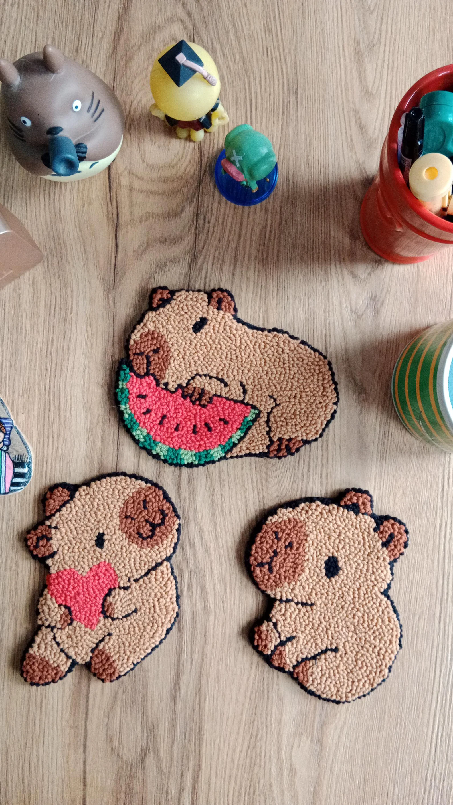Handmade punch needle coaster featuring a capybara design in brown and tan wool